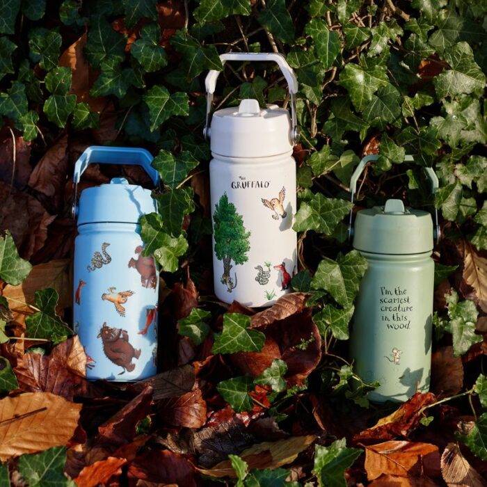 Three small stainless steel water bottles nestled amongst leaves and ivy all featuring characters from The Gruffalo